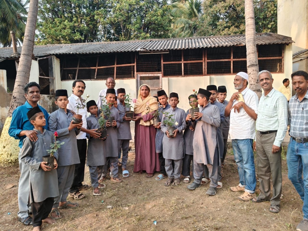 Boys and community members holding saplings for planting
