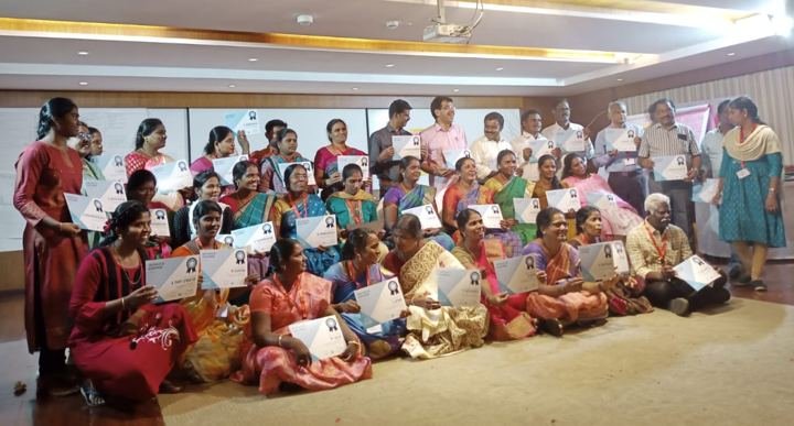 Women holding charts and papers at a training programme