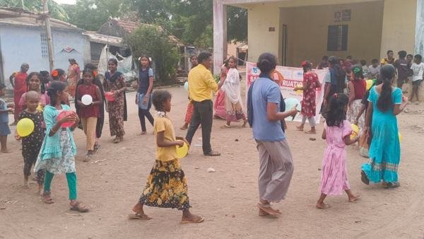 Children and villagers taking part in an outdoor awareness activity